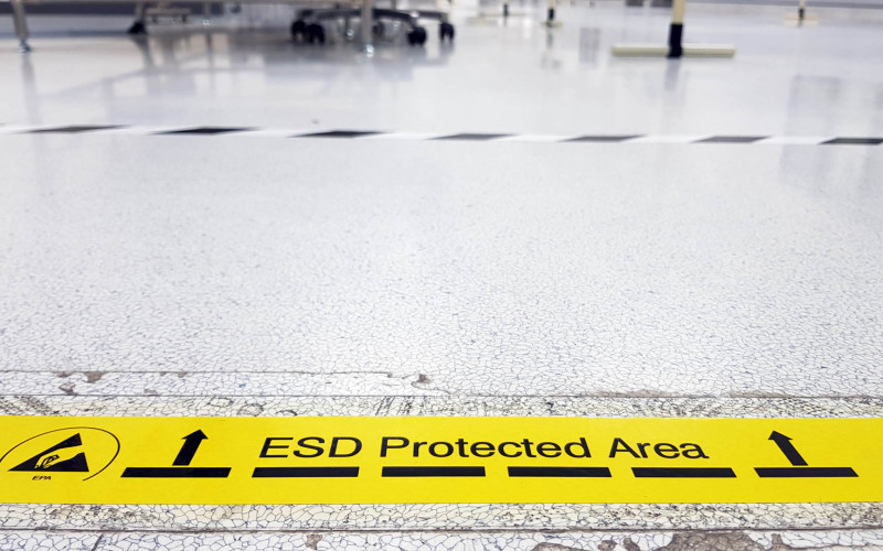 Ein gelbes Band kennzeichnet eine Industriehalle als ESD-geschützte Zone.