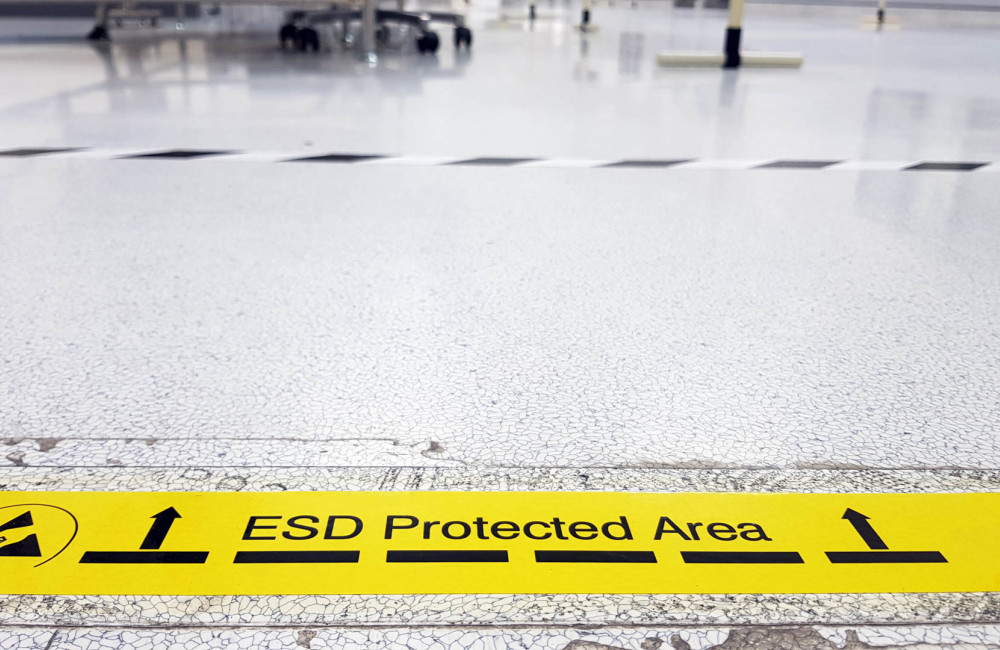 Ein gelbes Band kennzeichnet eine Industriehalle als ESD-geschützte Zone.