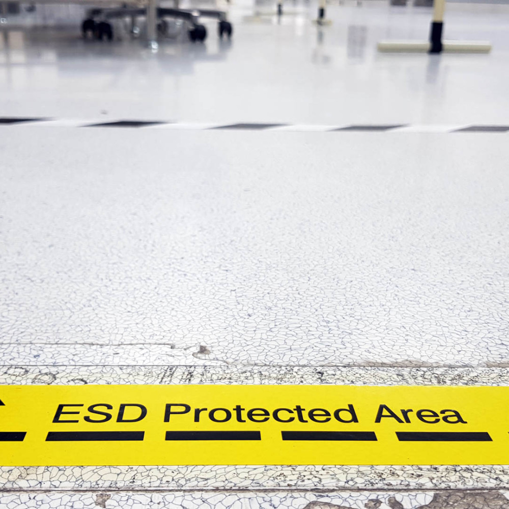 Ein gelbes Band kennzeichnet eine Industriehalle als ESD-geschützte Zone.