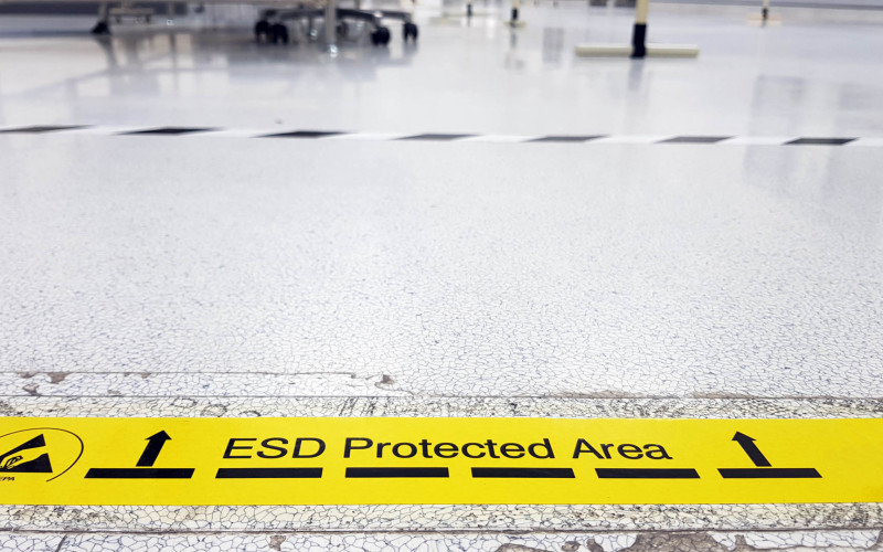 Ein gelbes Band kennzeichnet eine Industriehalle als ESD-geschützte Zone.
