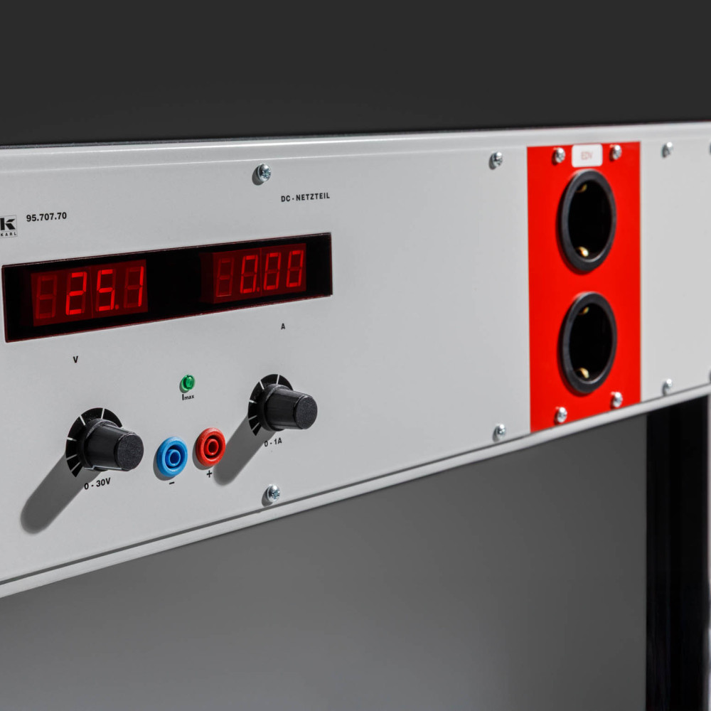 Auf der Modulleiste eines Arbeitstischs sind unterschiedliche Schnittstellen zusehen, darunter mehrere Schuko-Anschlüsse.